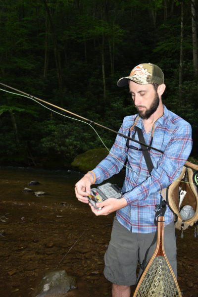 An image of an angler selecting a fly for night fishing