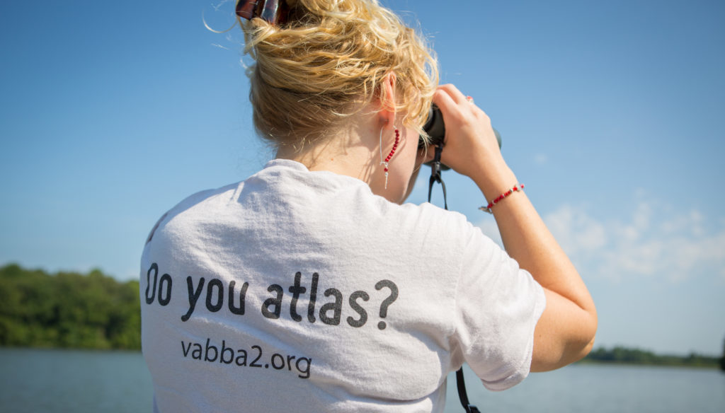 A woman with binoculars conducting a Virginia birding survey at Amelia WMA