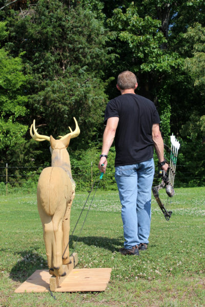 An image of a bow hunter with a 3D target of a deer