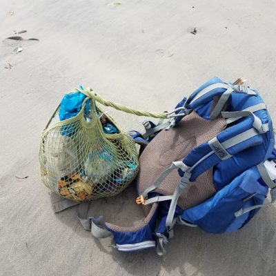 An image of a biologists backpack and the attached collected debris from the day