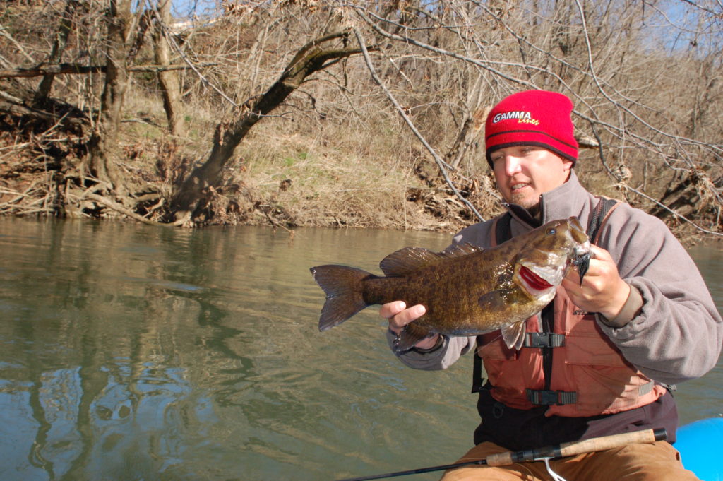 An image of the man from the raft holding a New River Smallmouth bass