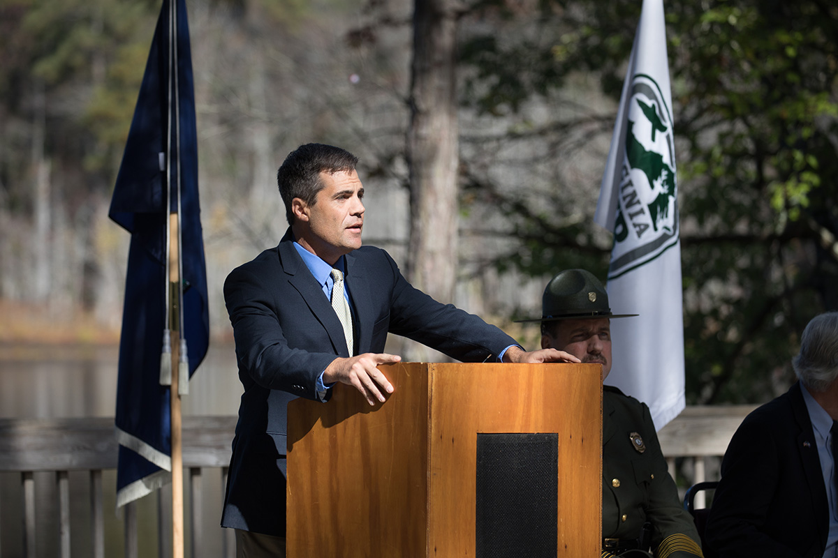An image of DWR Executive Director Ryan Brown speaking from a wooden podium at the dedication ceremony.