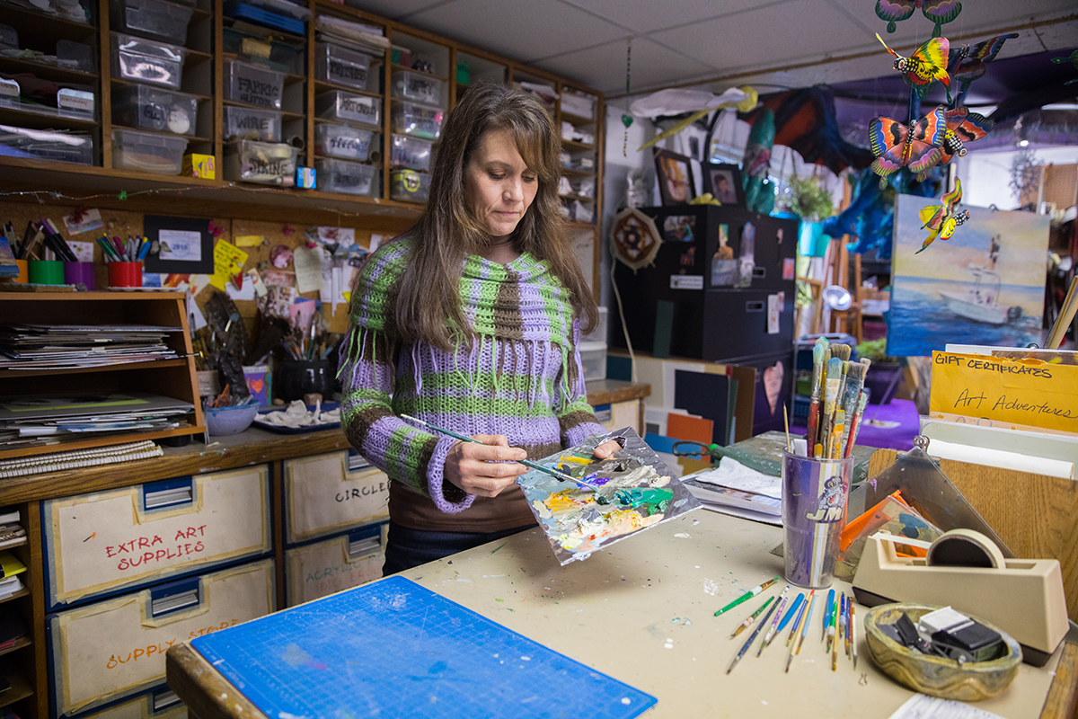An image of a woman in a art studio preparing a paint pallet