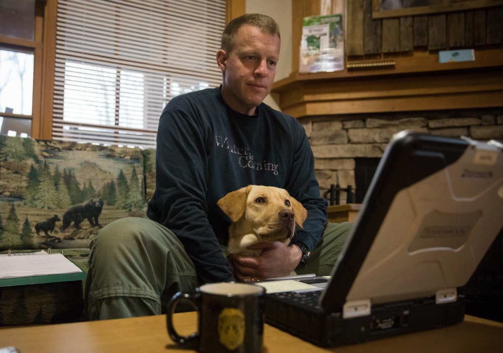 Lily the yellow lab and CPO Mark Diluigi reviewing tracking footage