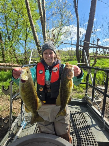 Angler on a boat holding two smallmouth bass from the Clinch River.