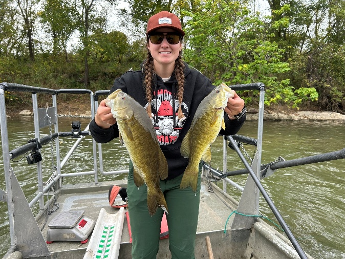 Angler on a boat holding a smallmouth bass on the Main Stem Shenandoah River.