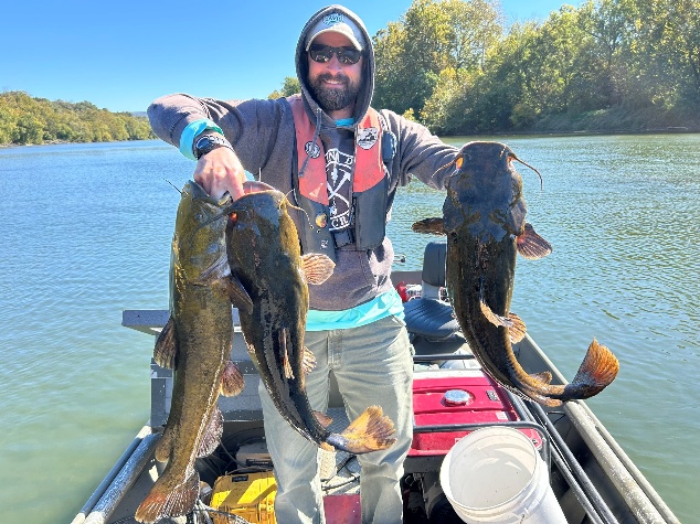 Angler on a boat holding a flathead catfish on the Main Stem Shenandoah River.