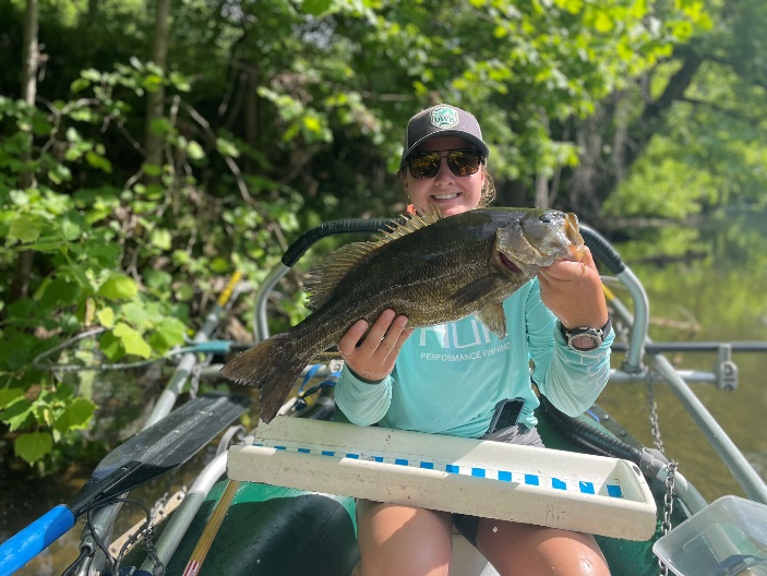 Angler on a boat holding a smallmouth bass from the Maury River.