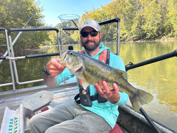 Angler on a boat holding a largemouth bass on the South Fork Shenandoah River.