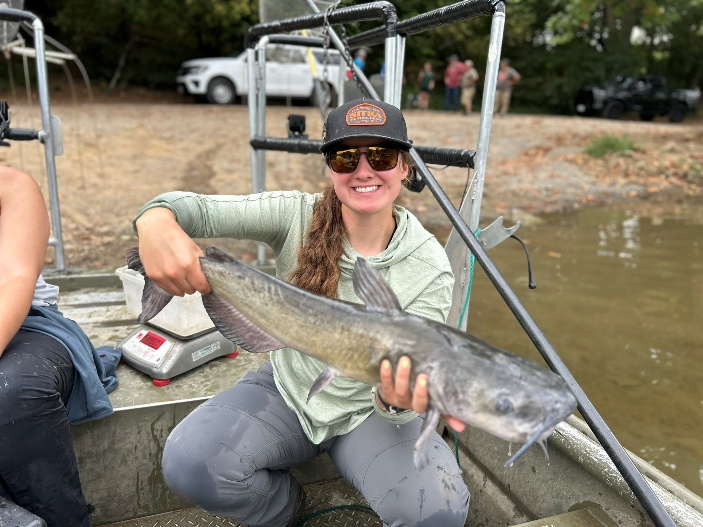 Angler on a boat holding a channel catfish on the South Fork Shenandoah River.