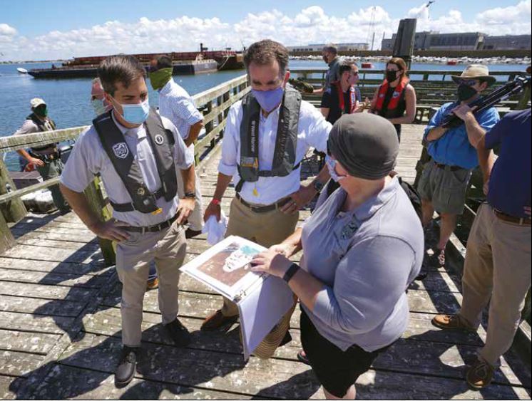 Wildlife biologists on a dock planning the alternative nesting habitat for the shorebirds