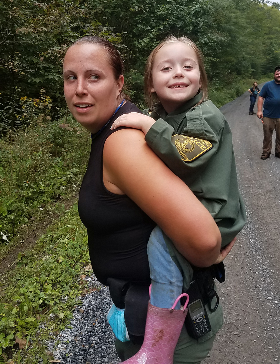 Senior CPO Beth McGuire and the young girl she helped out of the woods.