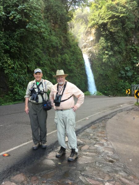 An image of Dave Larsen in Costa Rica standing on a road in front of a waterfall