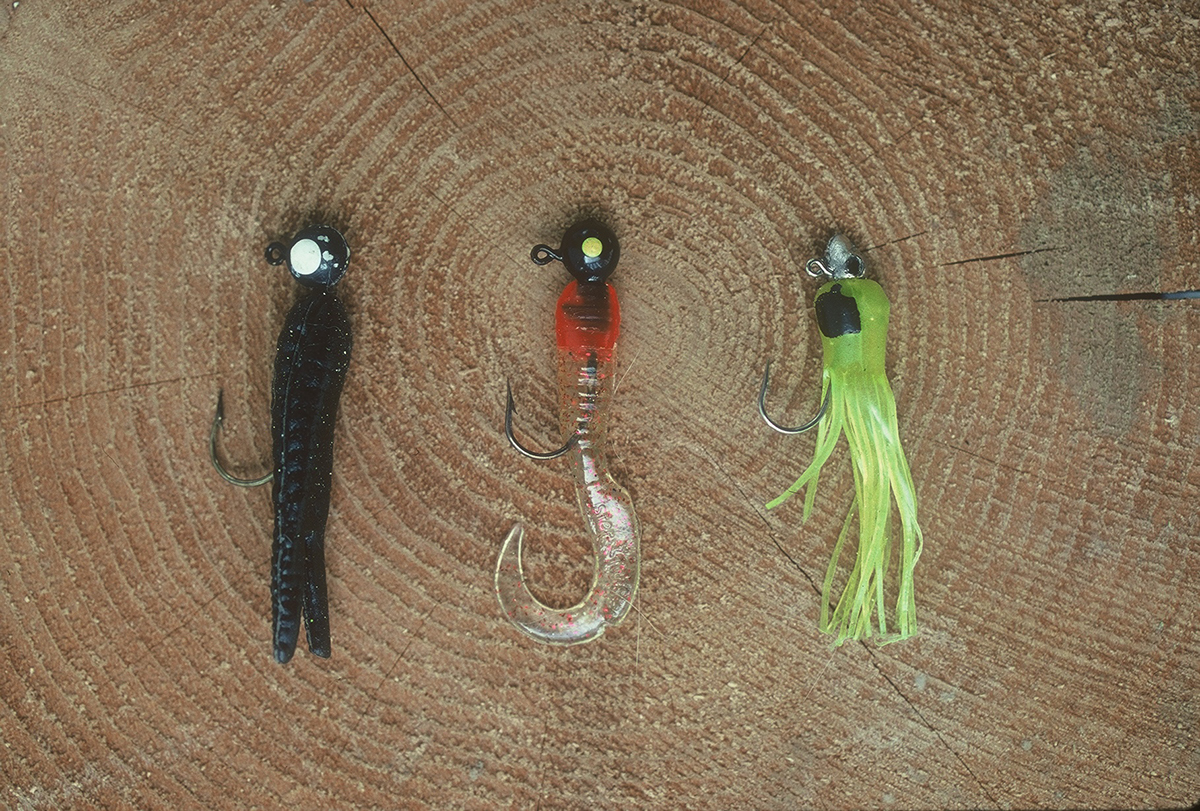An image of multiple baits known as crappie jigs; they are identifiable as having a head that has a painted eye upon in a flexible and colorful tail which is fed through the base of the hook allowing only the hook segment to be visable.