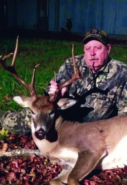 An image of a man and the deer he has shot and killed