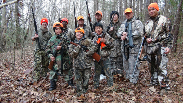 An image of many children holding guns wearing camouflage for hunting