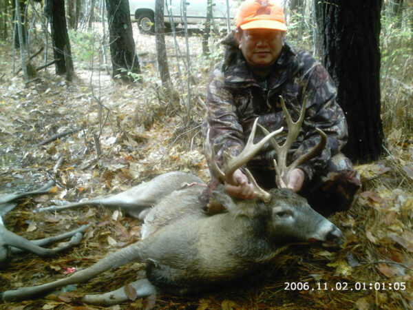 An image of a man and two dead deer that he has shot
