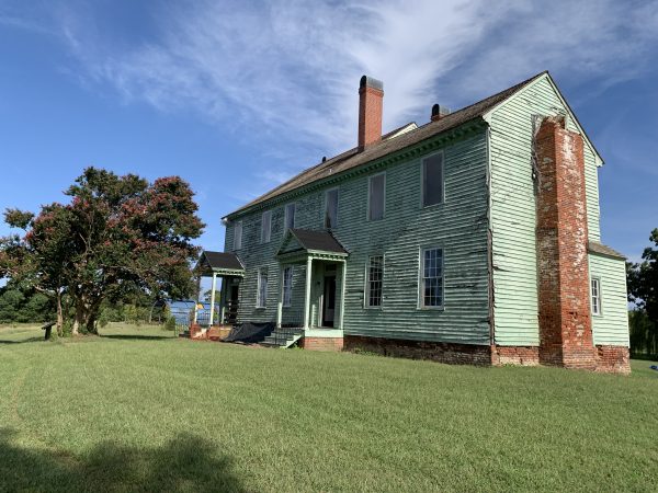 The Timberneck House (c.1793) it is currently being restored and has two doors, ten windows and a chimney; the wooden slats are a pale green in color and the accents are brick