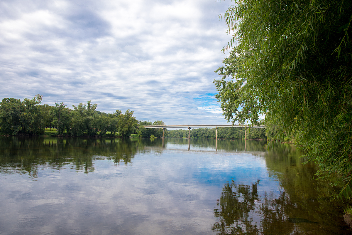 An image of the James river with a bridge and many trees visible