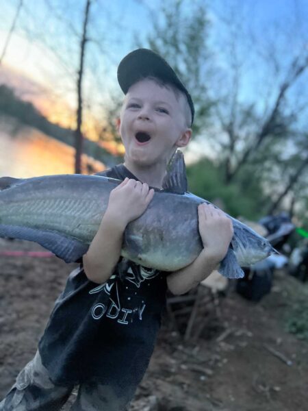 Dallas (age 5), holding a fish with both arms
