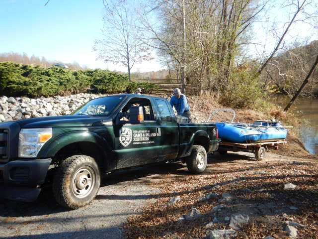 A green official DWR truck carrying the rafts back to storage after a successful day of sampling