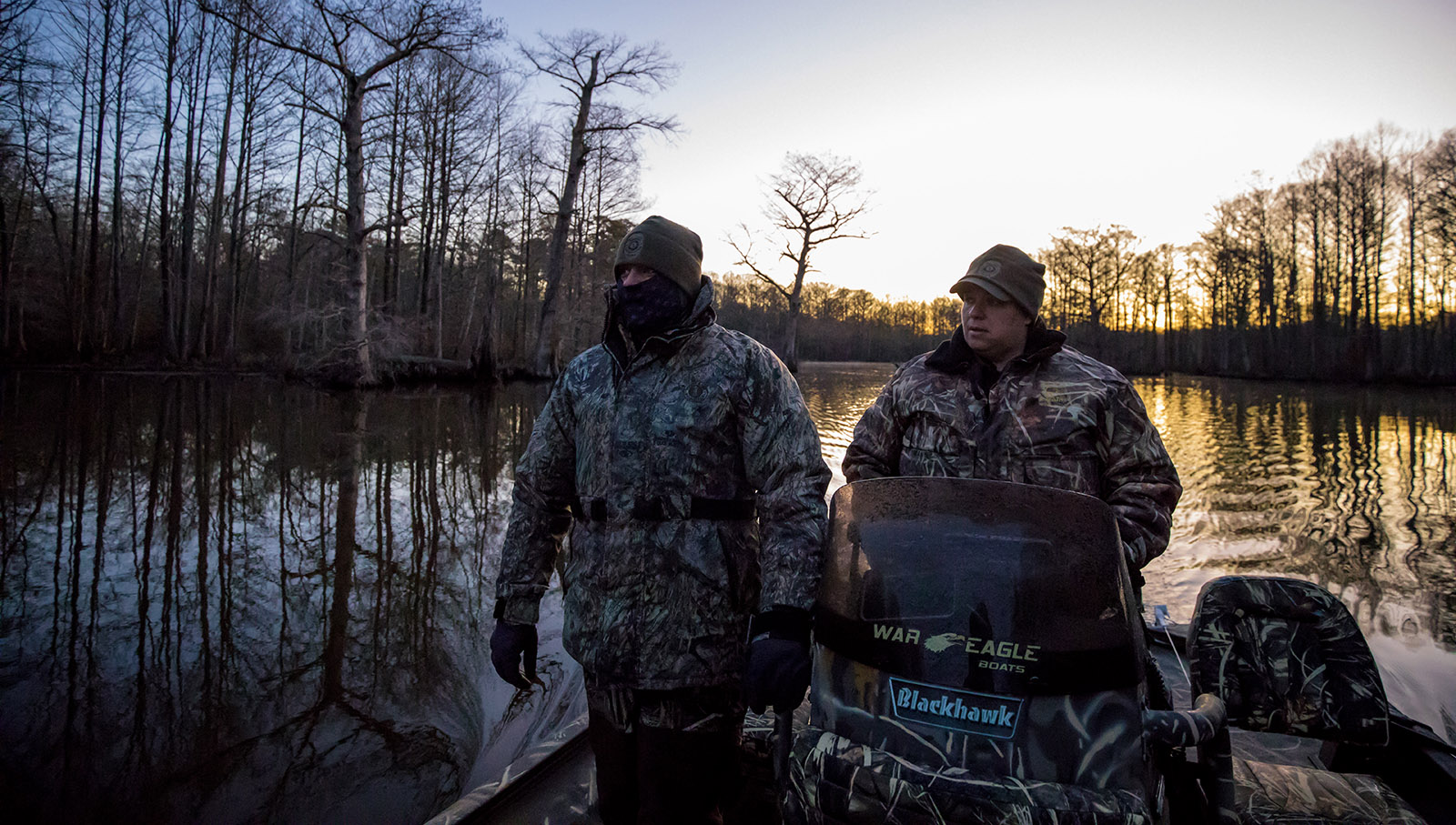 A photo of two Conservation Police Officers on a boat during winter, with many layers of clothes on.