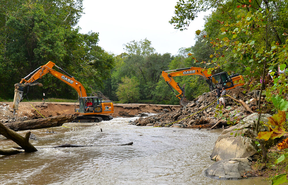 An image of two construction vehicles removing the dam imaged in the picture above