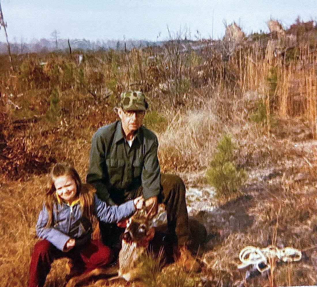 An image of a young five year old and her grandfather and the deer that they have hunted