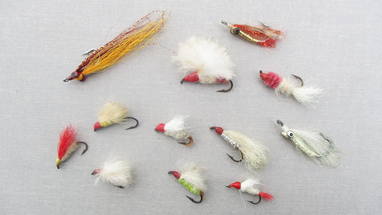 An image of 12 different flies of various color and material combinations. 