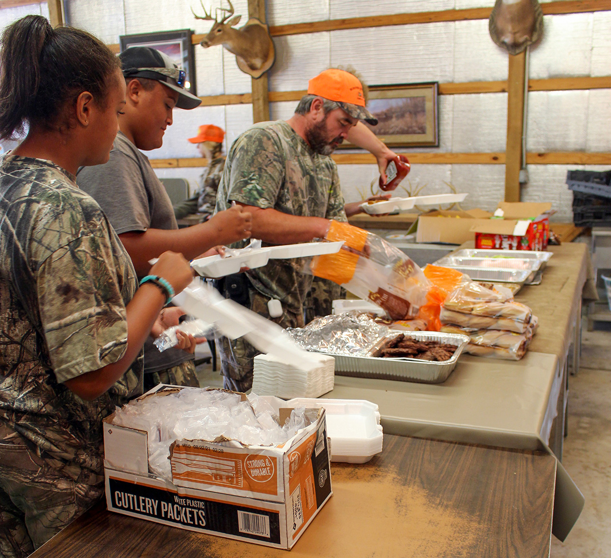 A photo of three people working together to prepare food.