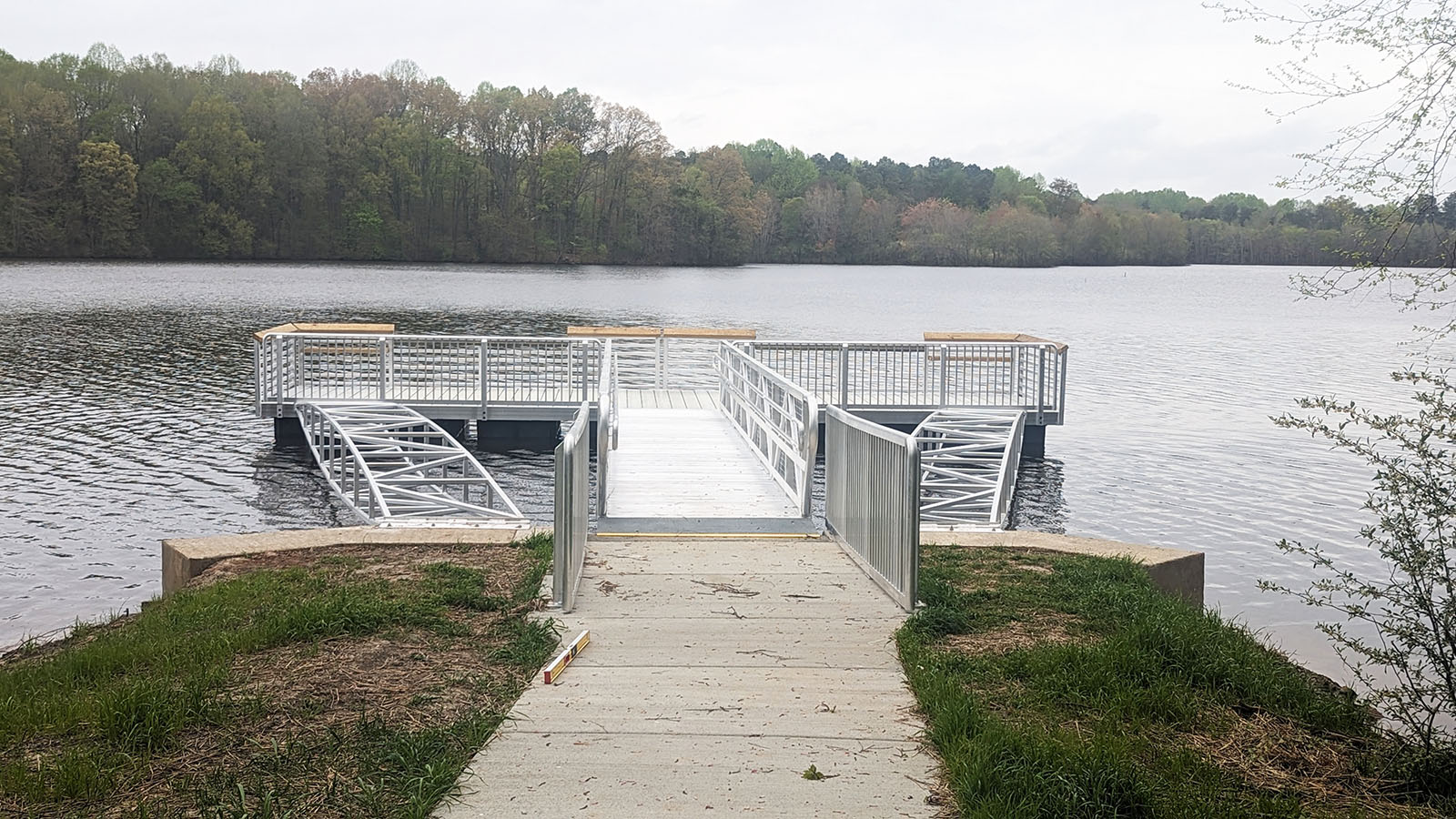A photo of a large, aluminum pier structure at the edge of a lake.