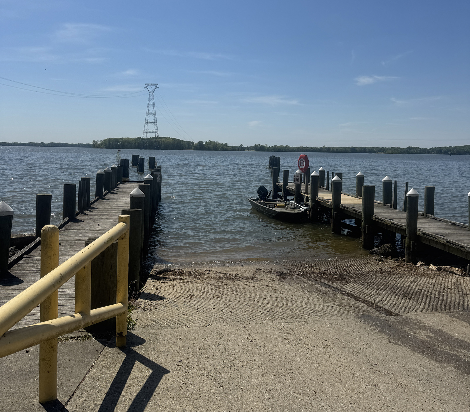 A photo of a concrete boat ramp with wooden docks framing it.