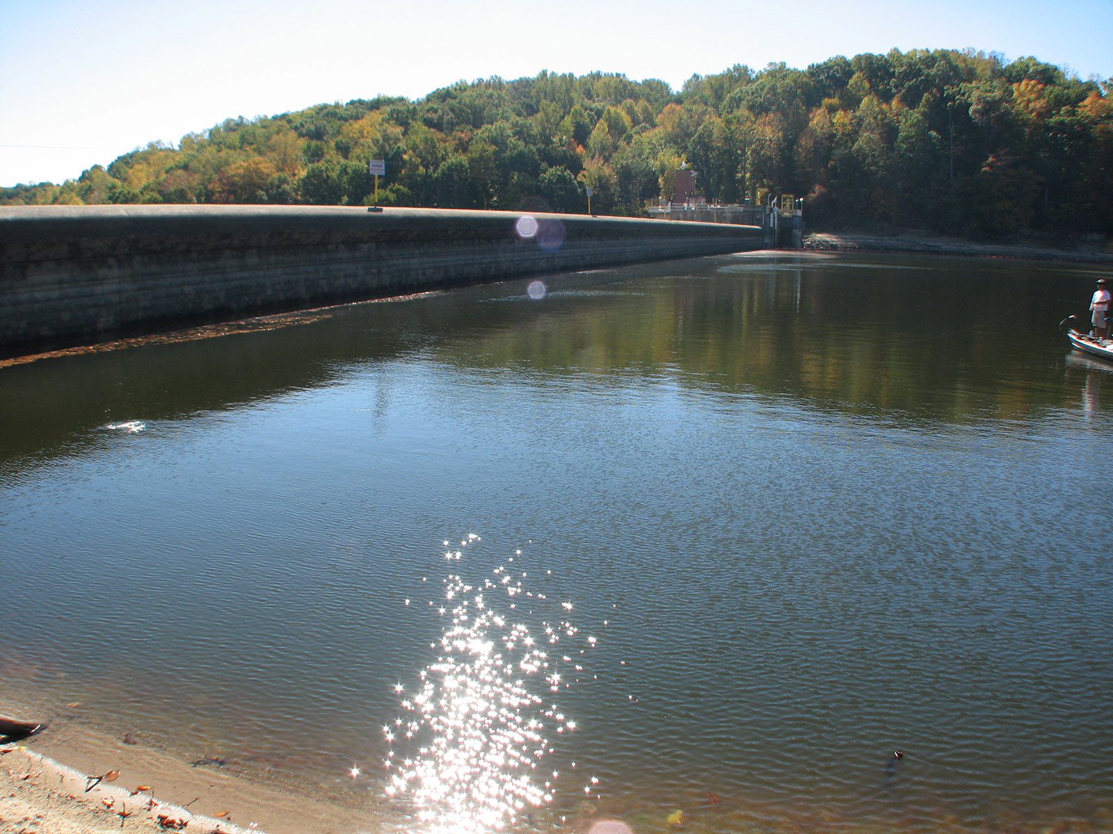 An image of a dam next to a lake
