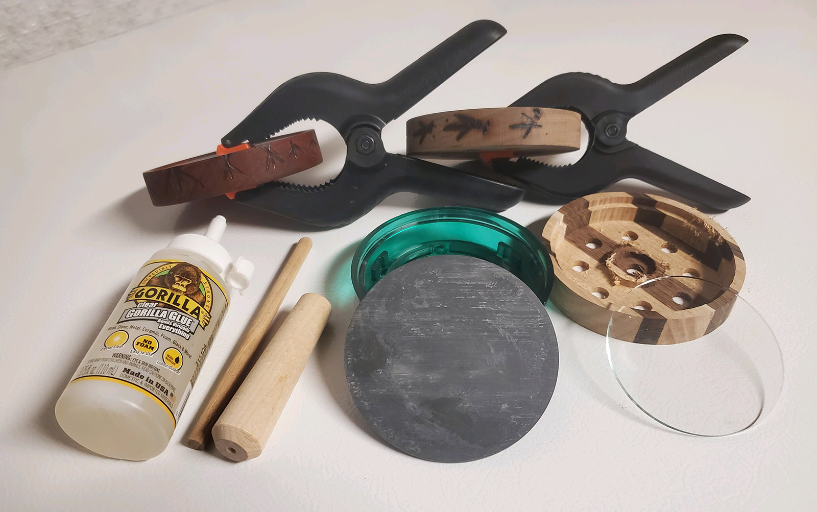A photo of glue, clamps, and the parts needed to make a pot turkey call.