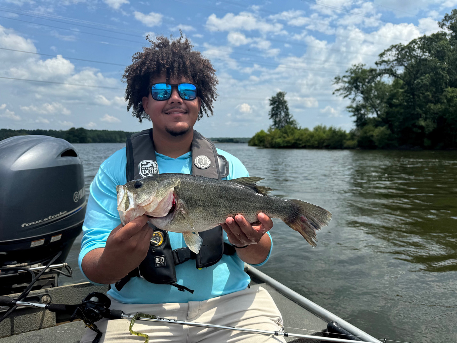 A photo of a man sitting in a boat, holding a large fish.