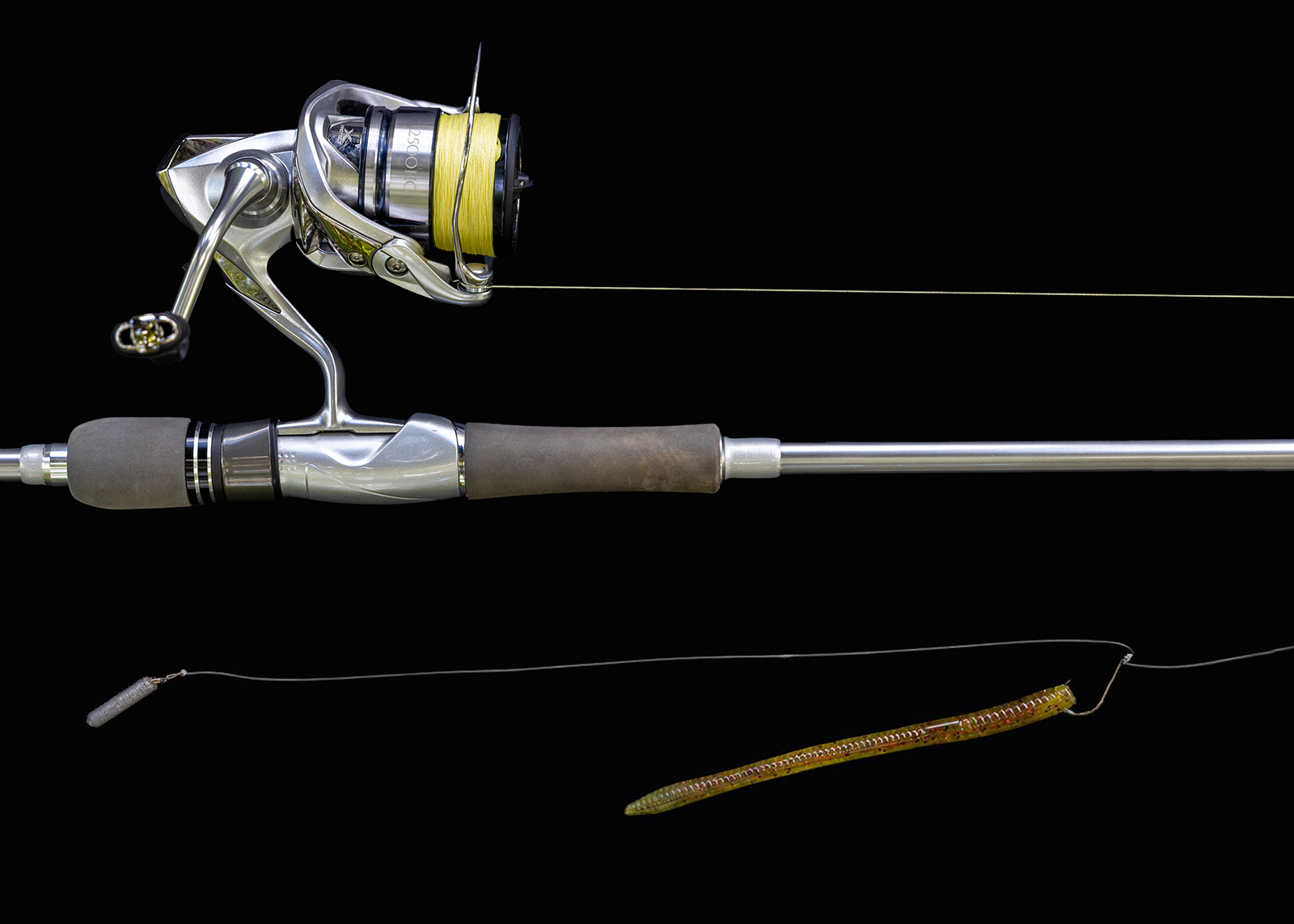 A close-up photo of a fishing rod and reel with a long plastic worm attached to a hook.