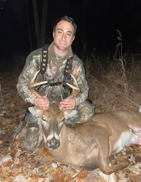 An image of a hunter and the deer he killed in the suburbs