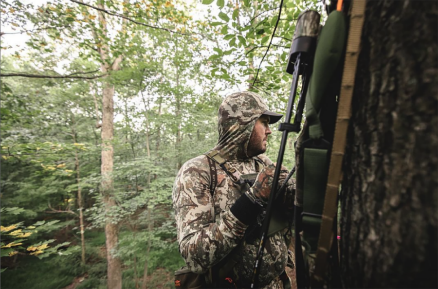 An image of a hunter in a tree blind within the suburbs