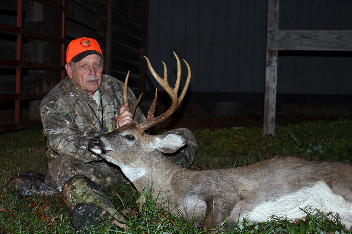 An image of a hunter posing with a deer he has shot