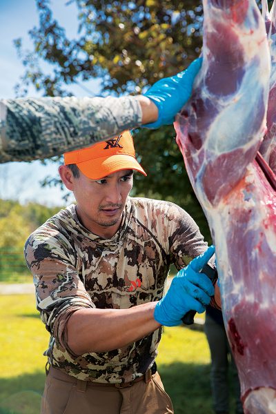 Wade Truong processes a deer during a workshop on processing wild game.