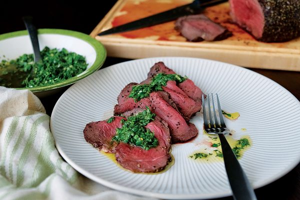 One of many dishes prepared with venison—black pepper-crusted venison roast with chimichurri.
