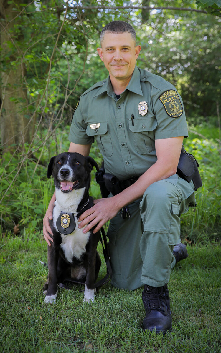 An Image of Frank Spuchesi with his retired K9 officer a black and white dog named Comet
