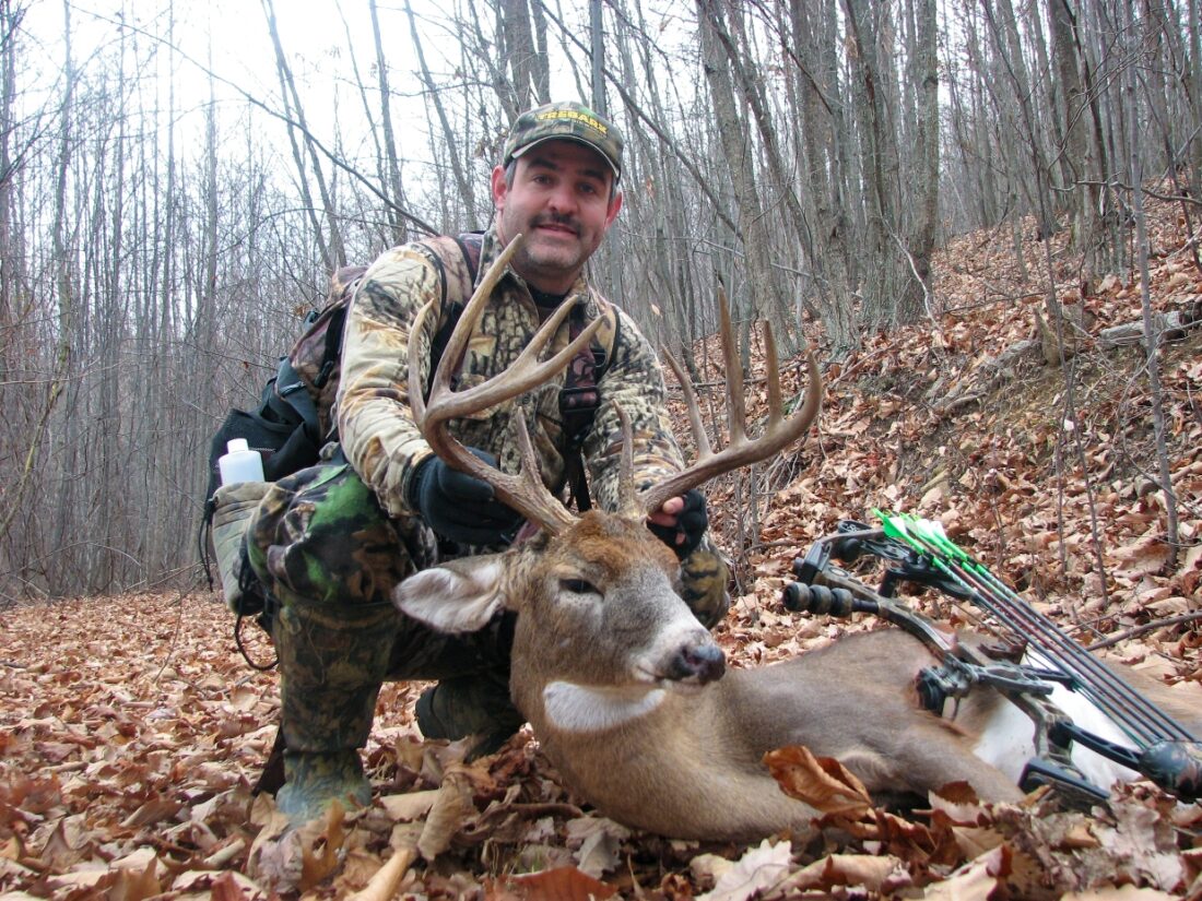 An image of a man with a dead deer he had killed with a bow and arrow