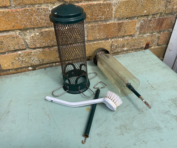 Bird feeders and cleaning supplies laid out on a table