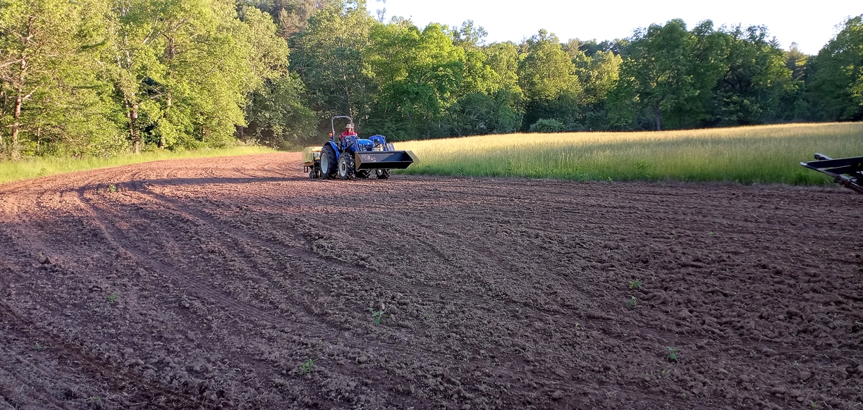 An image of a tractor sowing seeds for the wildlife corridor 