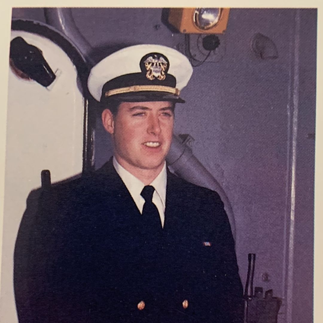 An older photo of a young man in a Navy uniform.