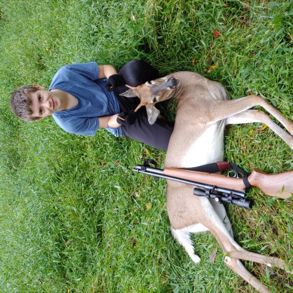 An image of a boy and the deer he has killed