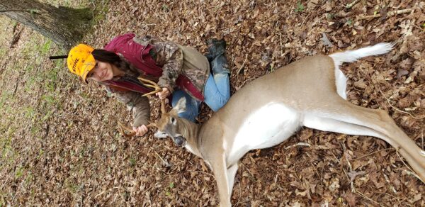 An image of a girl and the deer she has killed