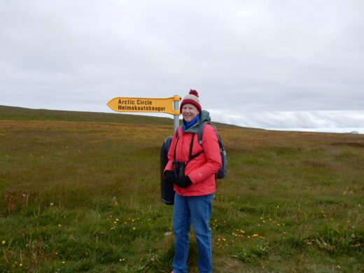 A girl standing in a meadow at the artic circle