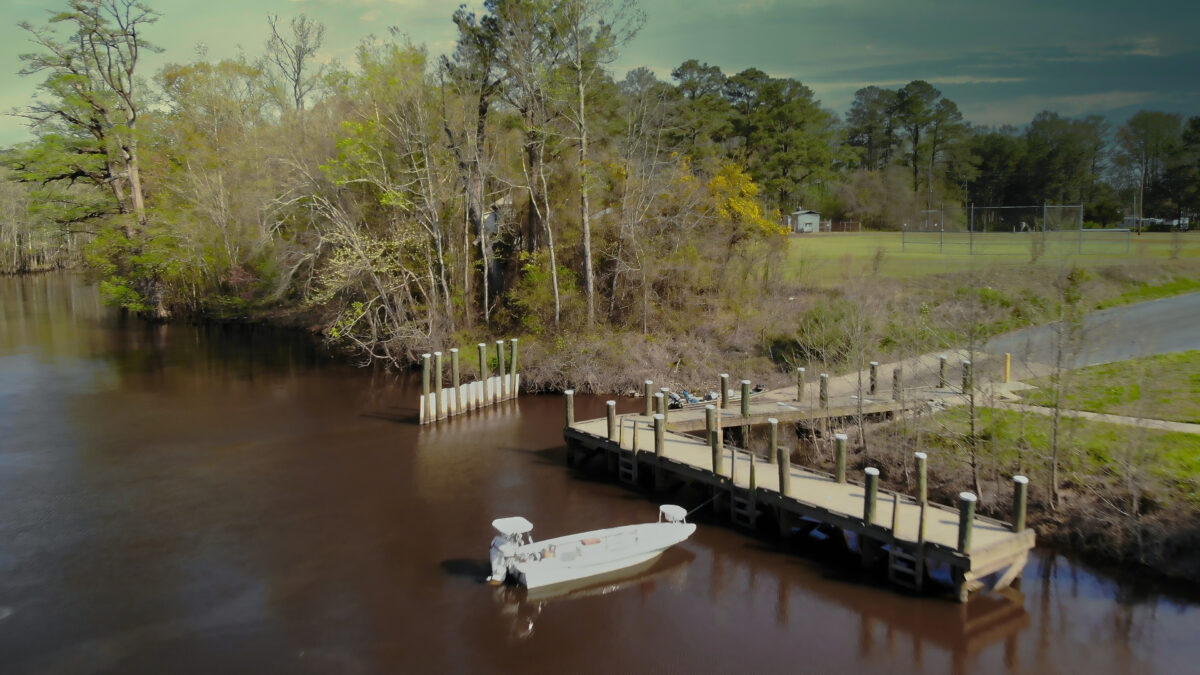 An image of a boat named Hercules docking at a wooden dock in the Nottoway river